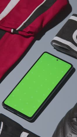 Vertical-Video-Studio-Flat-Lay-Shot-Of-Football-Soccer-Boots-Shirt-Captains-Armband-And-Mobile-Phone-2